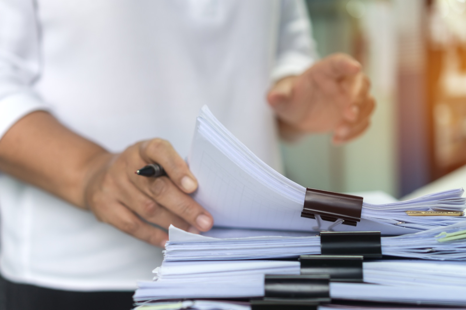 Hands organizing medical documents on a desk