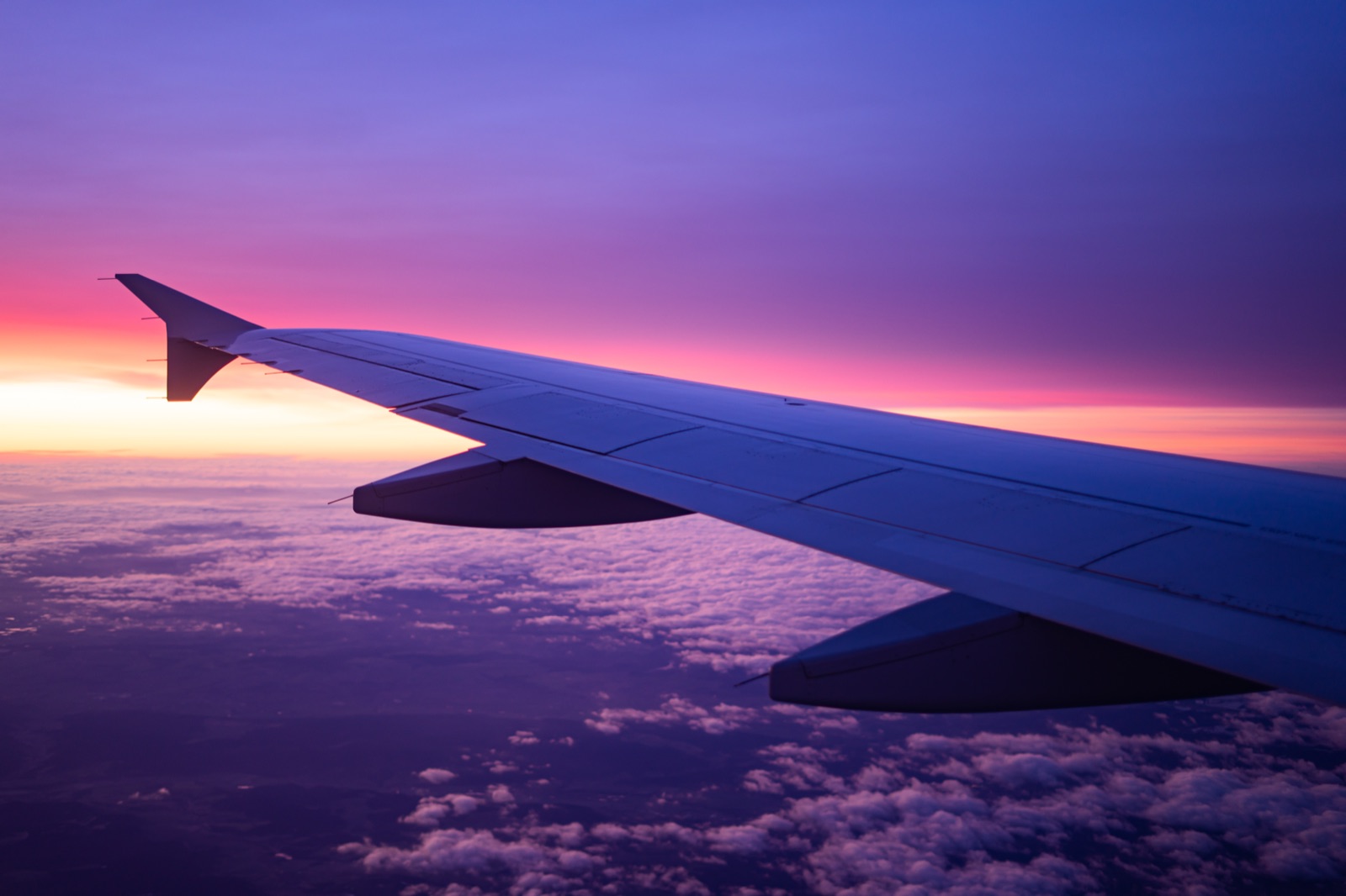 View from an aircraft window above the clouds at sunrise