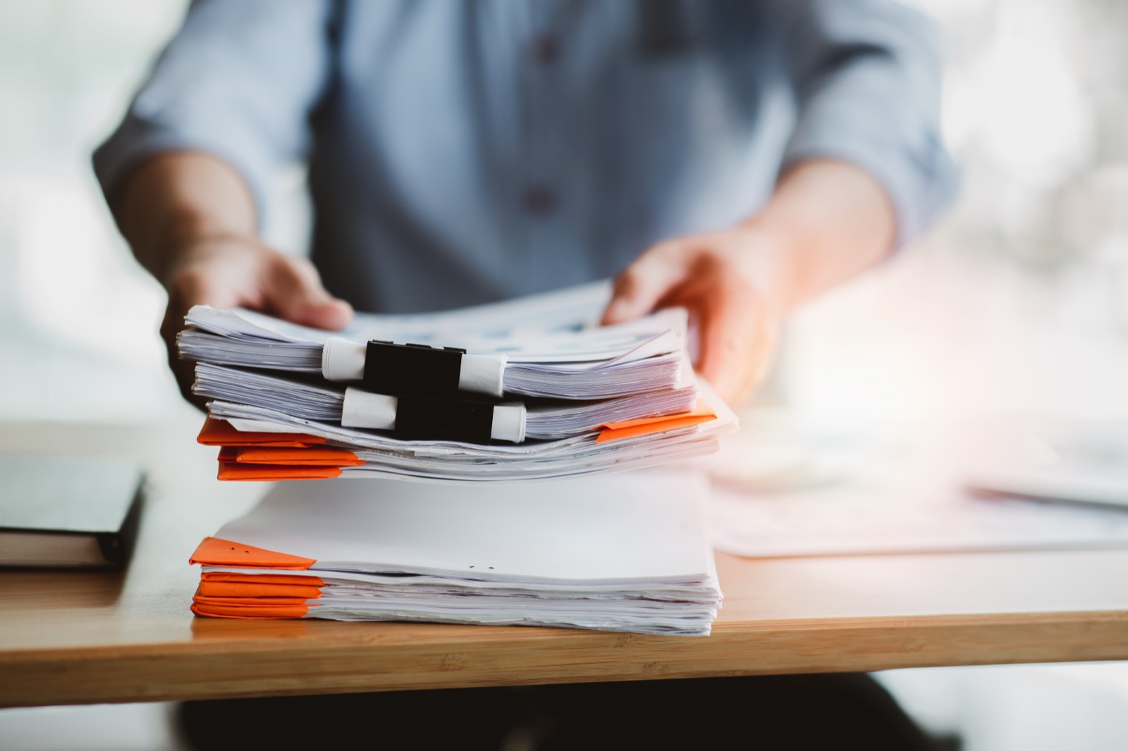 A person working at a laptop with documents